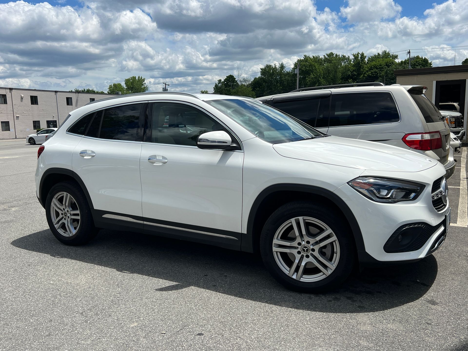 A white mercedes benz gla is parked in a parking lot.
