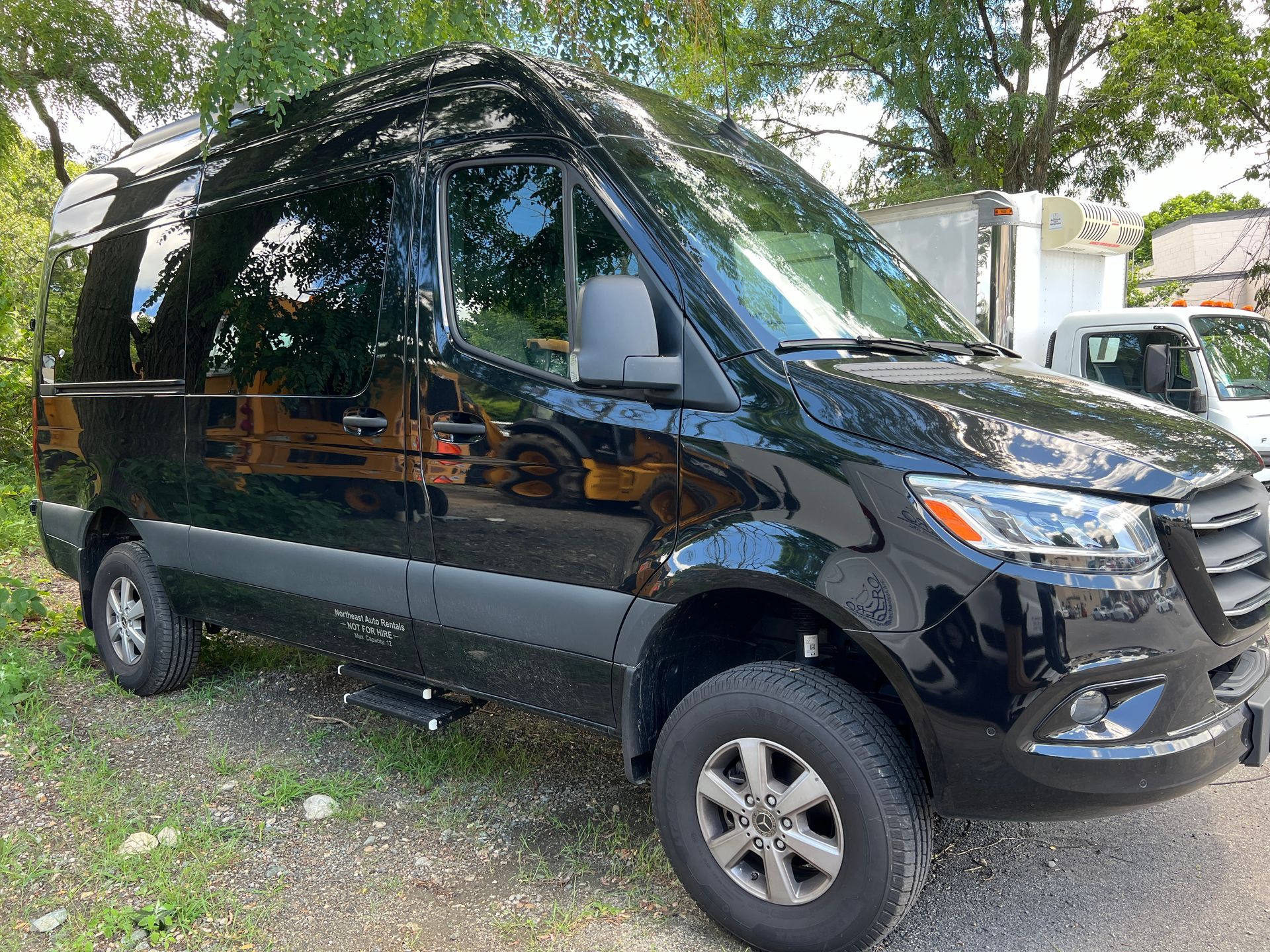 A black van is parked on the side of the road.