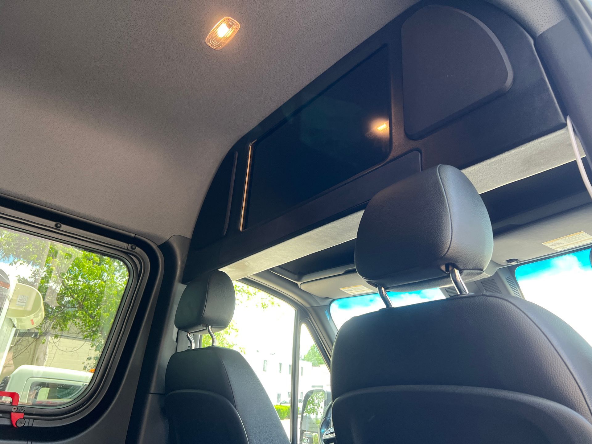 The inside of a van with a roof rack above the seats