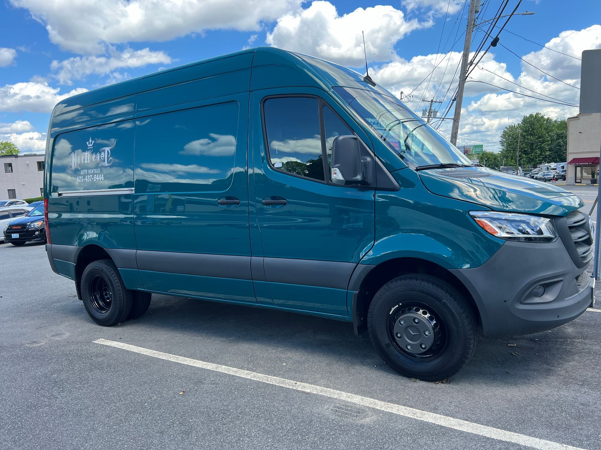 A blue van is parked in a parking lot.