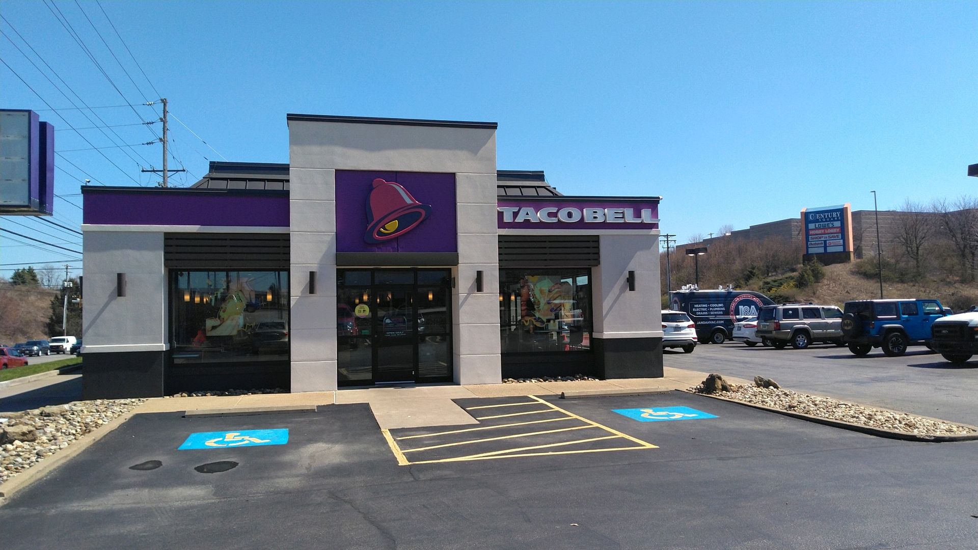 Taco Bell storefront with accessible parking spaces under a clear blue sky