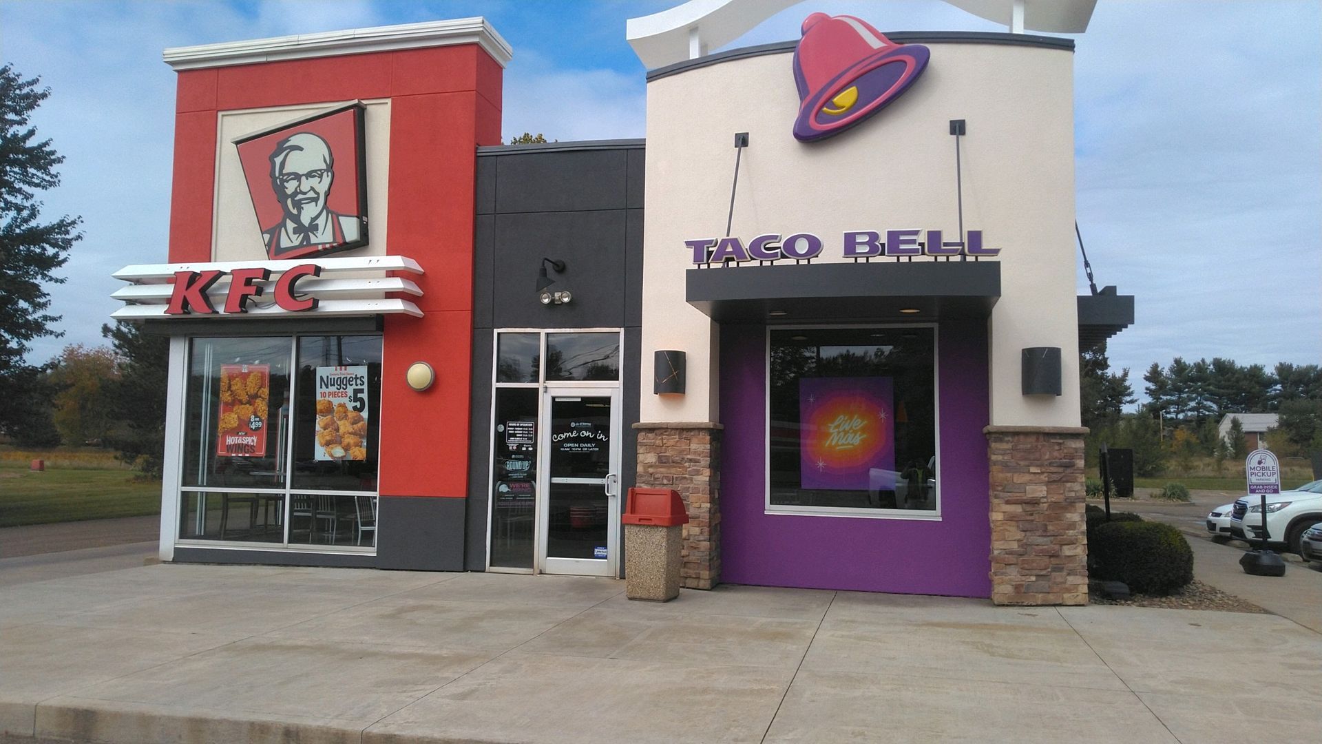 KFC and Taco Bell side-by-side storefronts with red and purple branding on a roadside strip