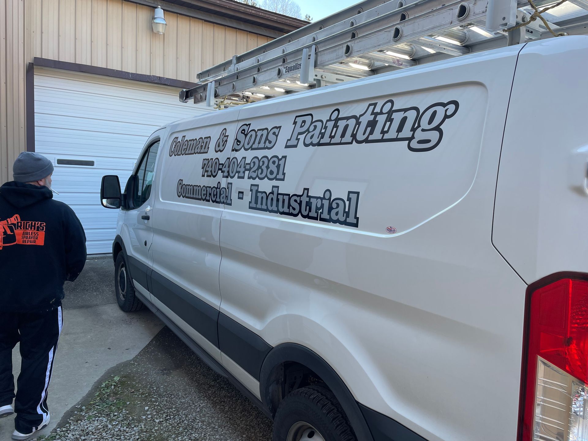 White work van with “Moss Painting” logo parked by a garage, with a person walking nearby