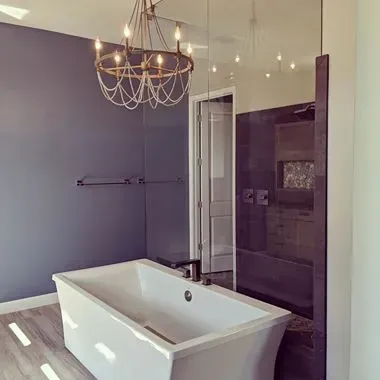 A bathroom with a bathtub and a chandelier hanging from the ceiling.