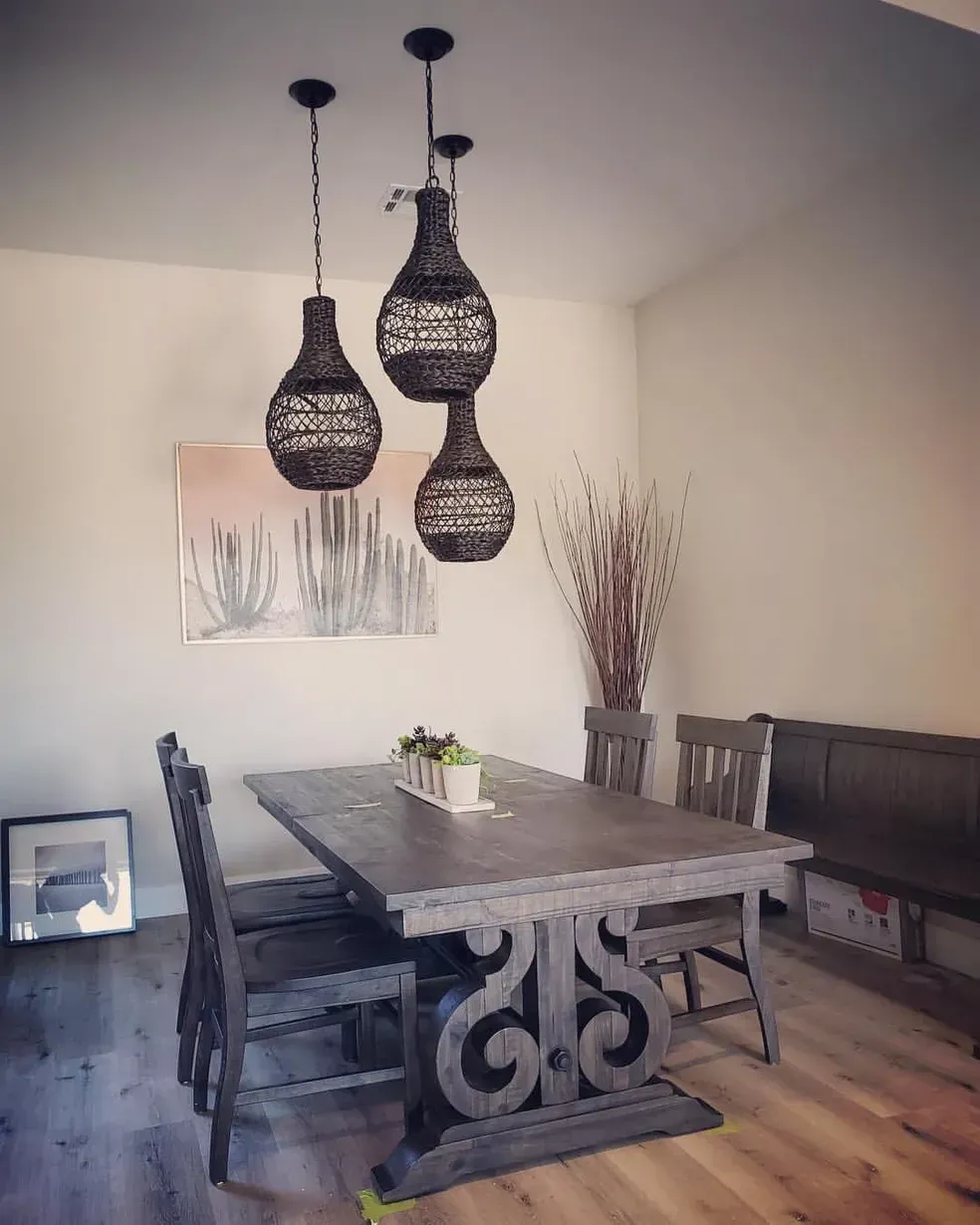 A dining room with a table and chairs and a painting on the wall.