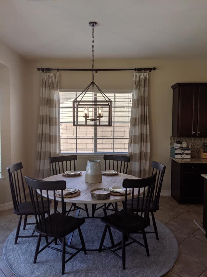 A dining room with a table and chairs and a chandelier hanging from the ceiling.