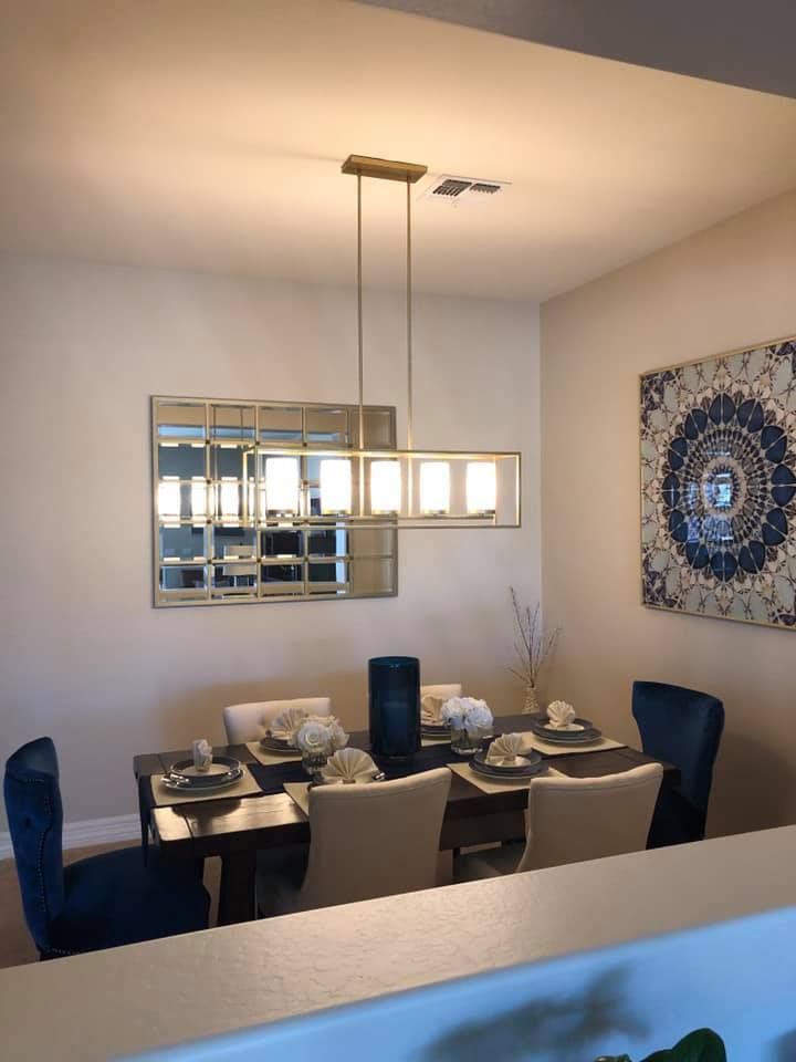 A dining room with a table and chairs and a chandelier hanging from the ceiling.