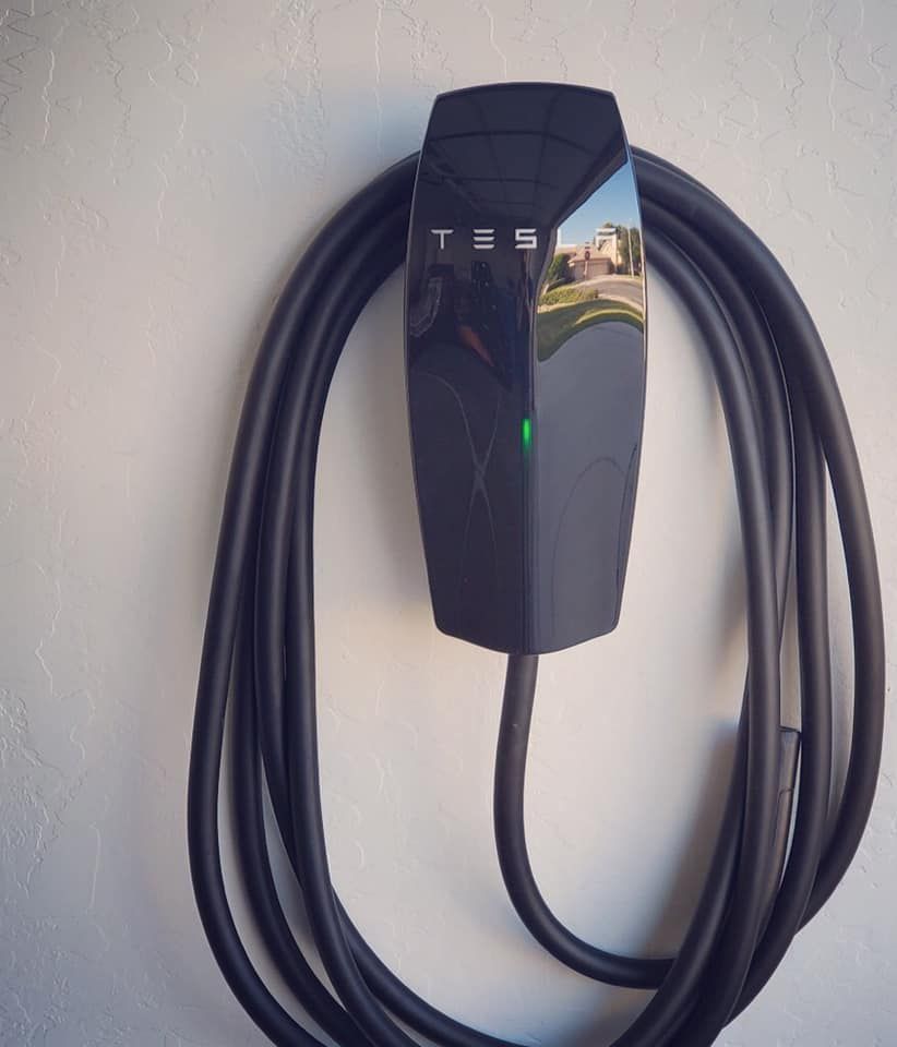 A tesla charger is attached to a wall