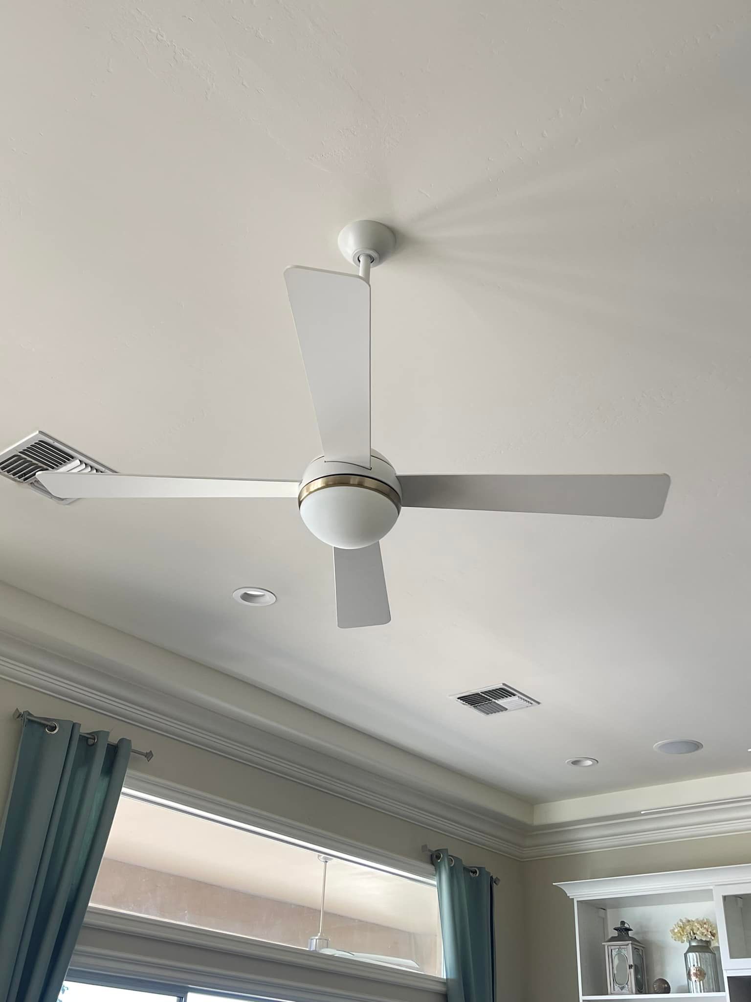A white ceiling fan is hanging from the ceiling of a living room.