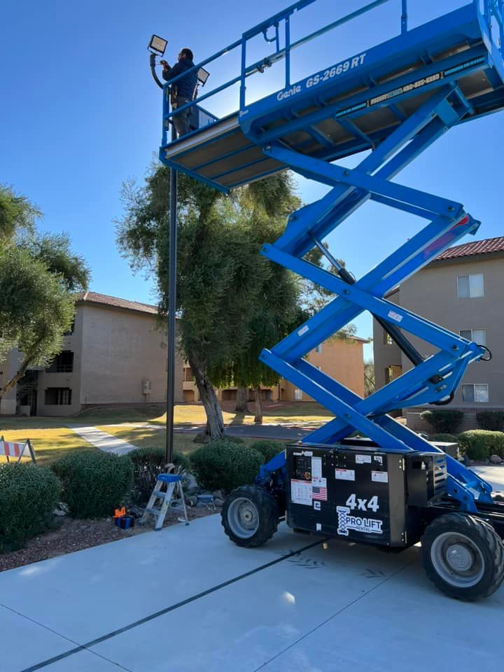 A man is working on a light pole on a scissor lift.