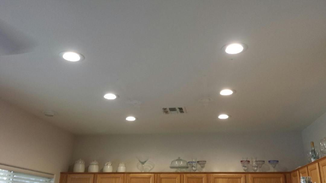A kitchen with a lot of lights on the ceiling.