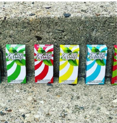 Four boxes of mints are lined up in a row