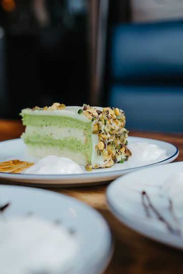 A slice of cake is on a plate on a table.