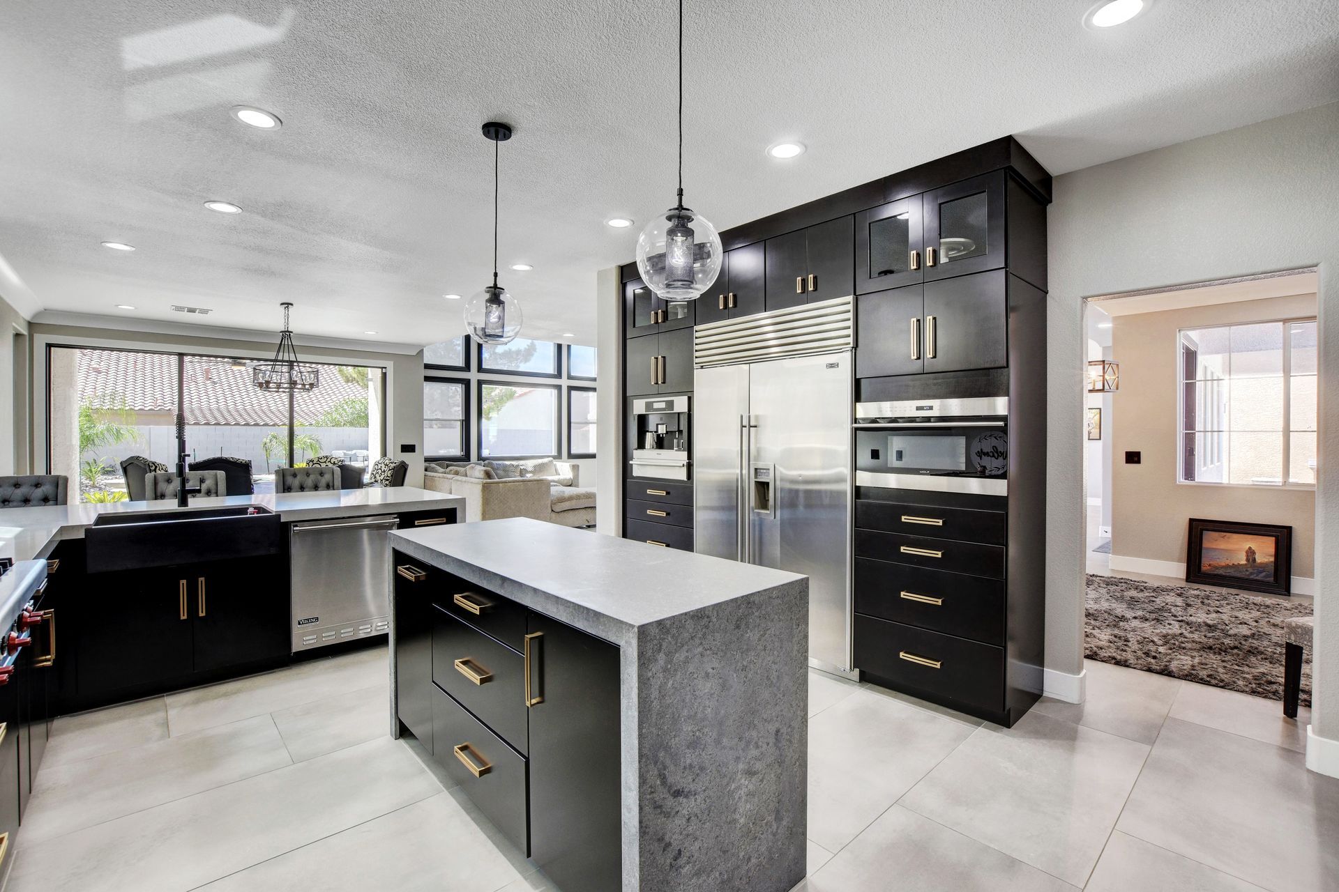 Modern kitchen with dark cabinetry, stainless steel appliances, and a gray island.