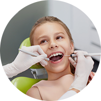 a young girl is getting her teeth examined by a dentist