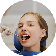 a woman is getting her teeth examined by a dentist