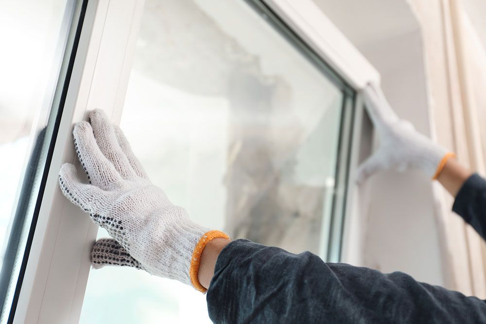 person installing new windows on a house