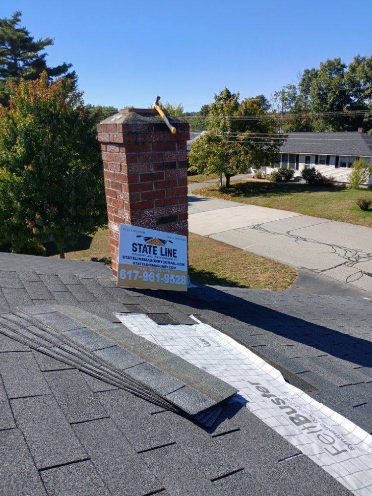 Rooftop with chimney and sign for State Line roofing, asphalt shingles, blue sky.