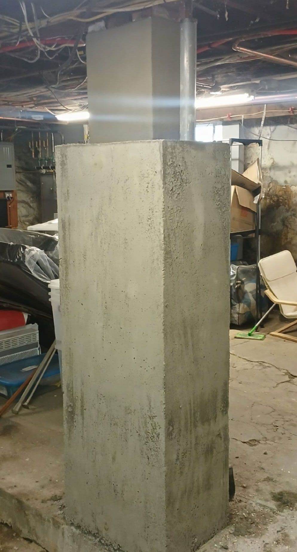 Two gray concrete support columns in a basement.