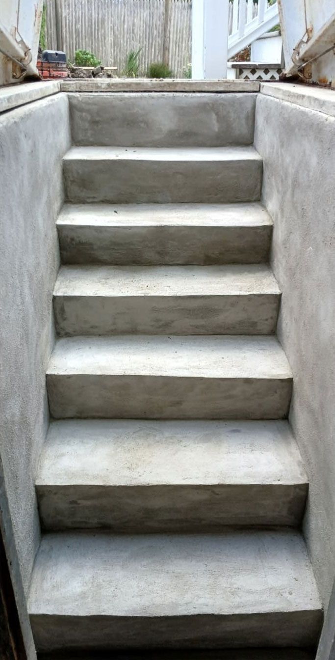 Concrete stairs leading up, flanked by concrete walls.