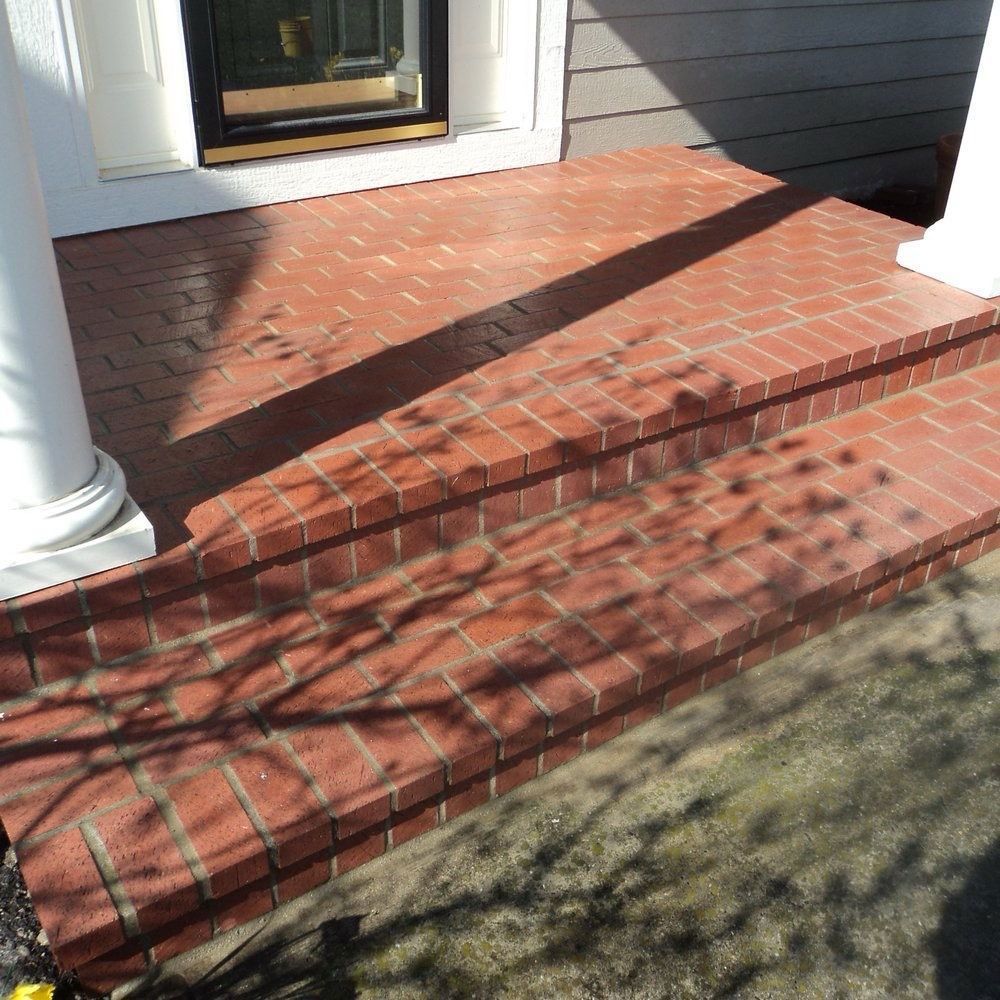 Brick front porch with two steps, cast shadows.
