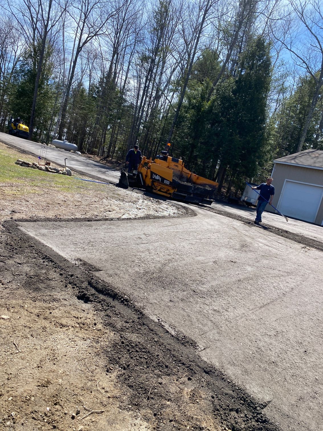A man is standing on the side of a road next to a yellow truck