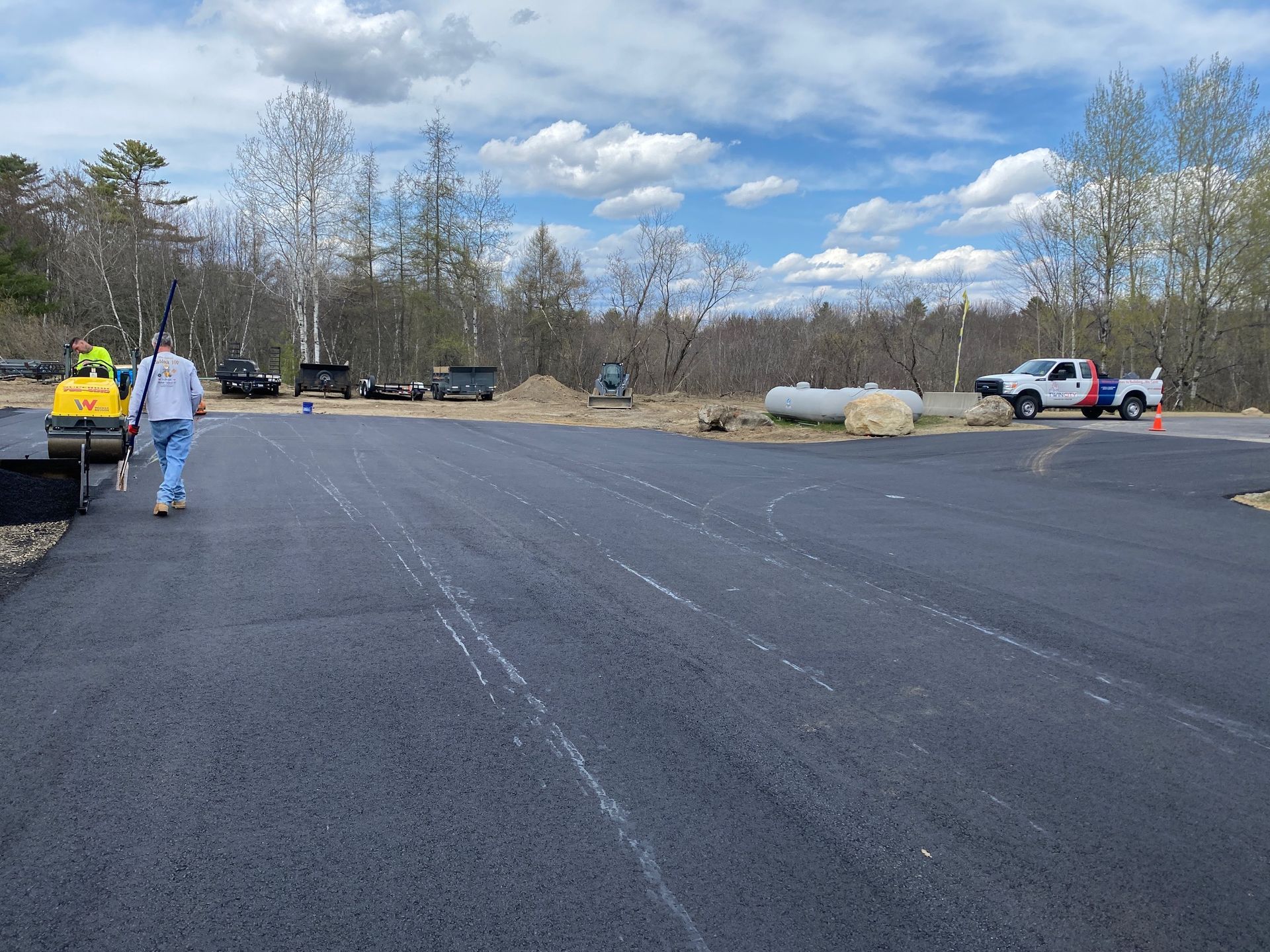 A man is walking down a road in a parking lot
