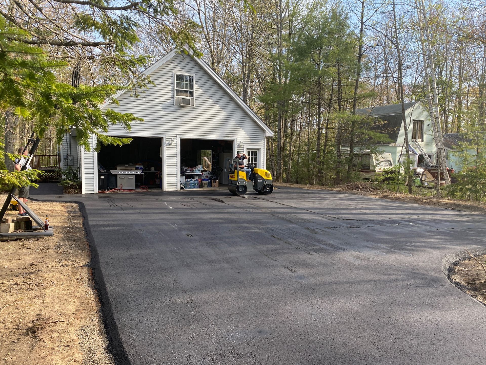 A yellow forklift is parked in front of a garage