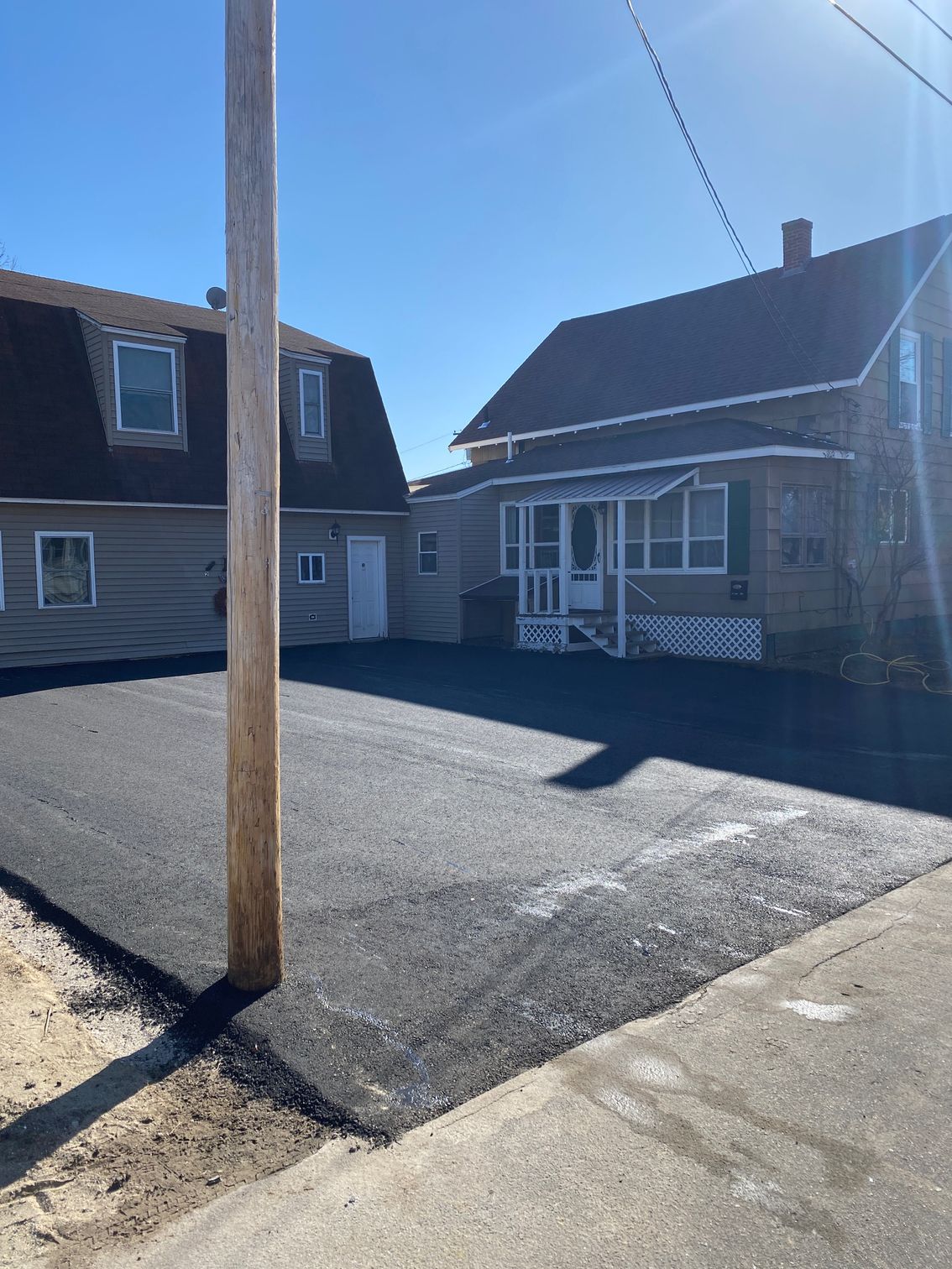 A house with a driveway and a telephone pole in front of it