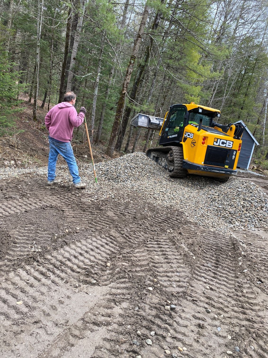 A man is standing next to a bulldozer on a dirt road