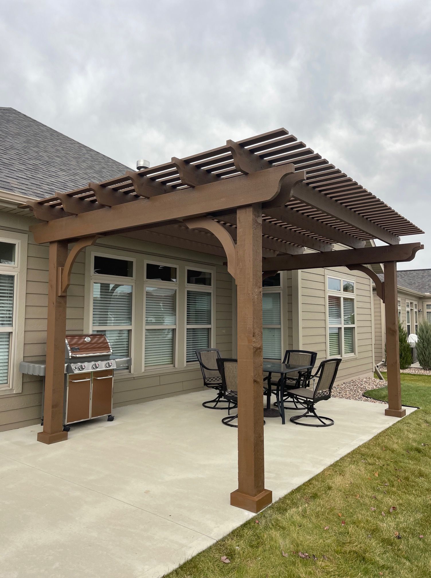 There is a pergola with a table and chairs underneath it.