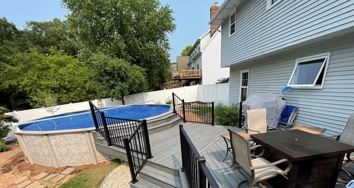 There is a swimming pool in the backyard of a house.