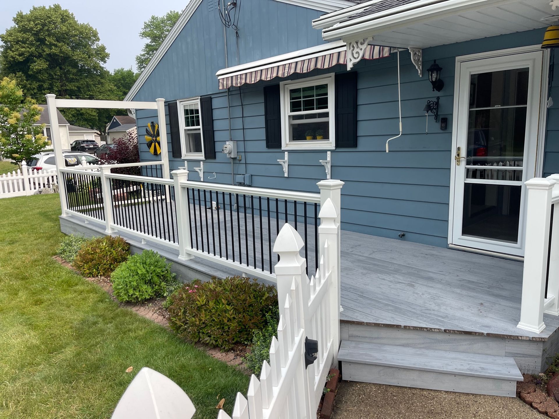 A blue house with a white picket fence and a porch.