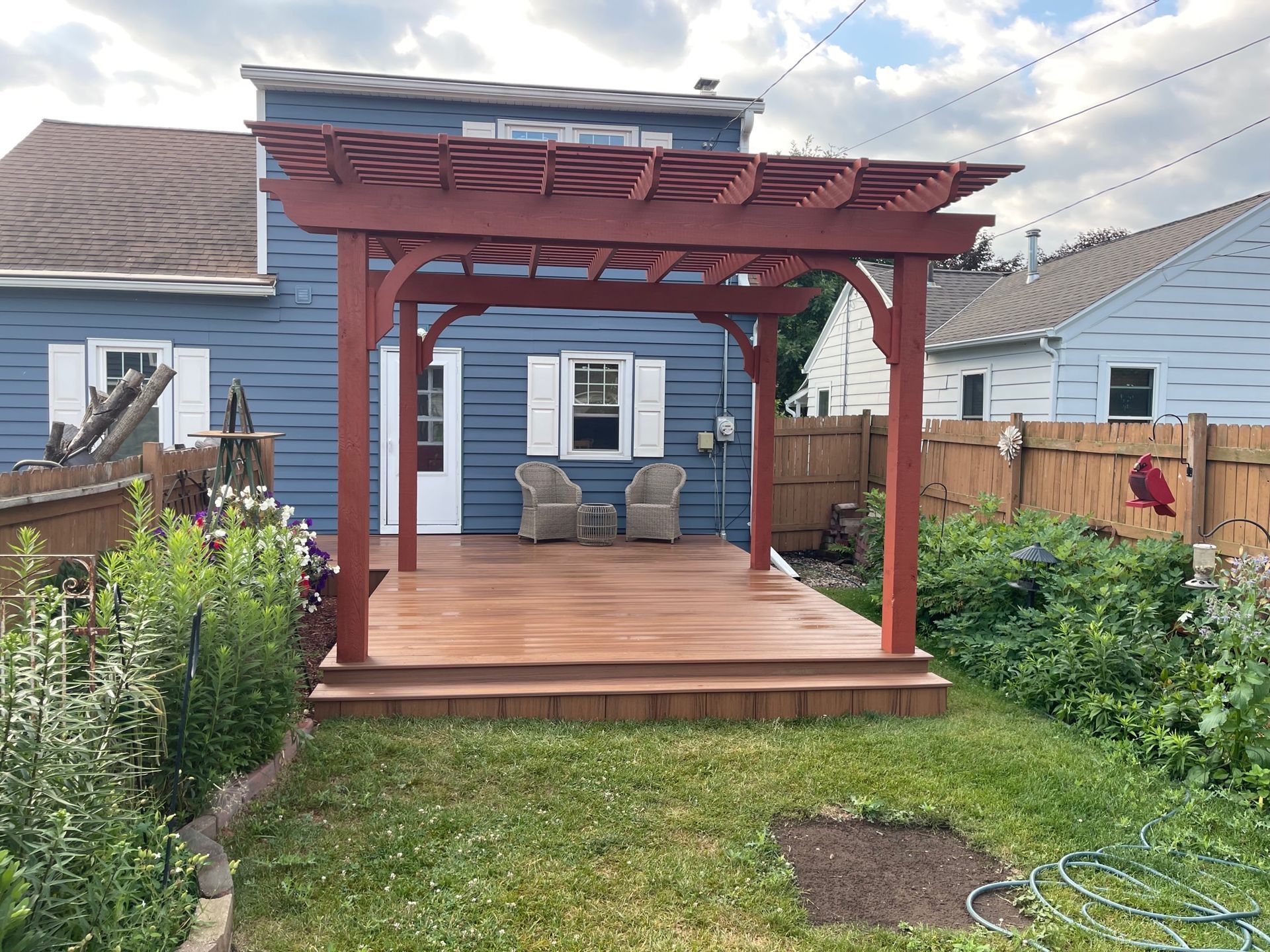There is a pergola in the backyard of a house.