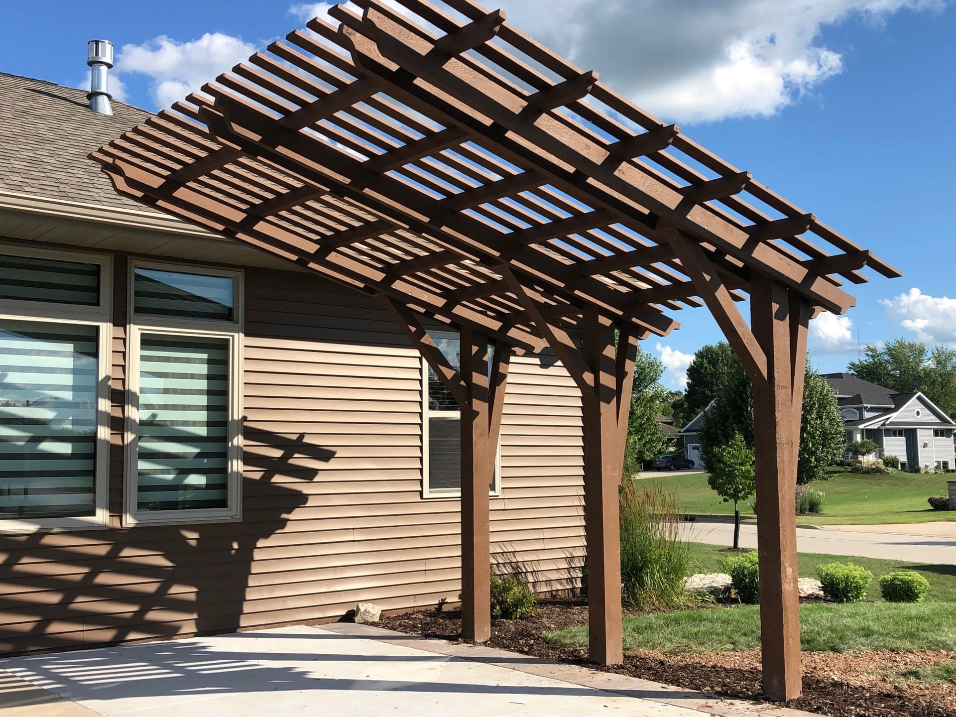 A house with a wooden pergola in front of it