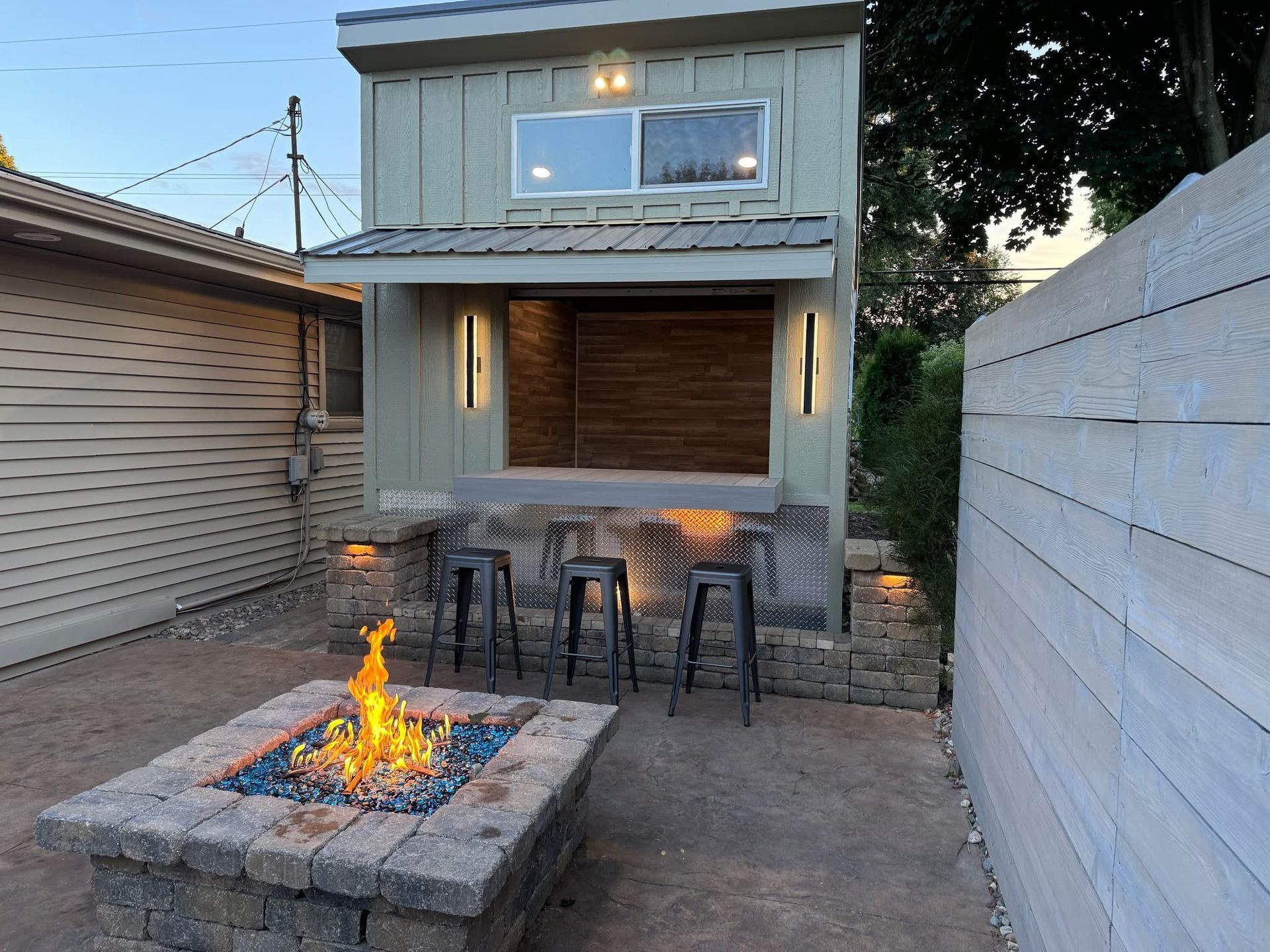 A fire pit is in front of a small house.