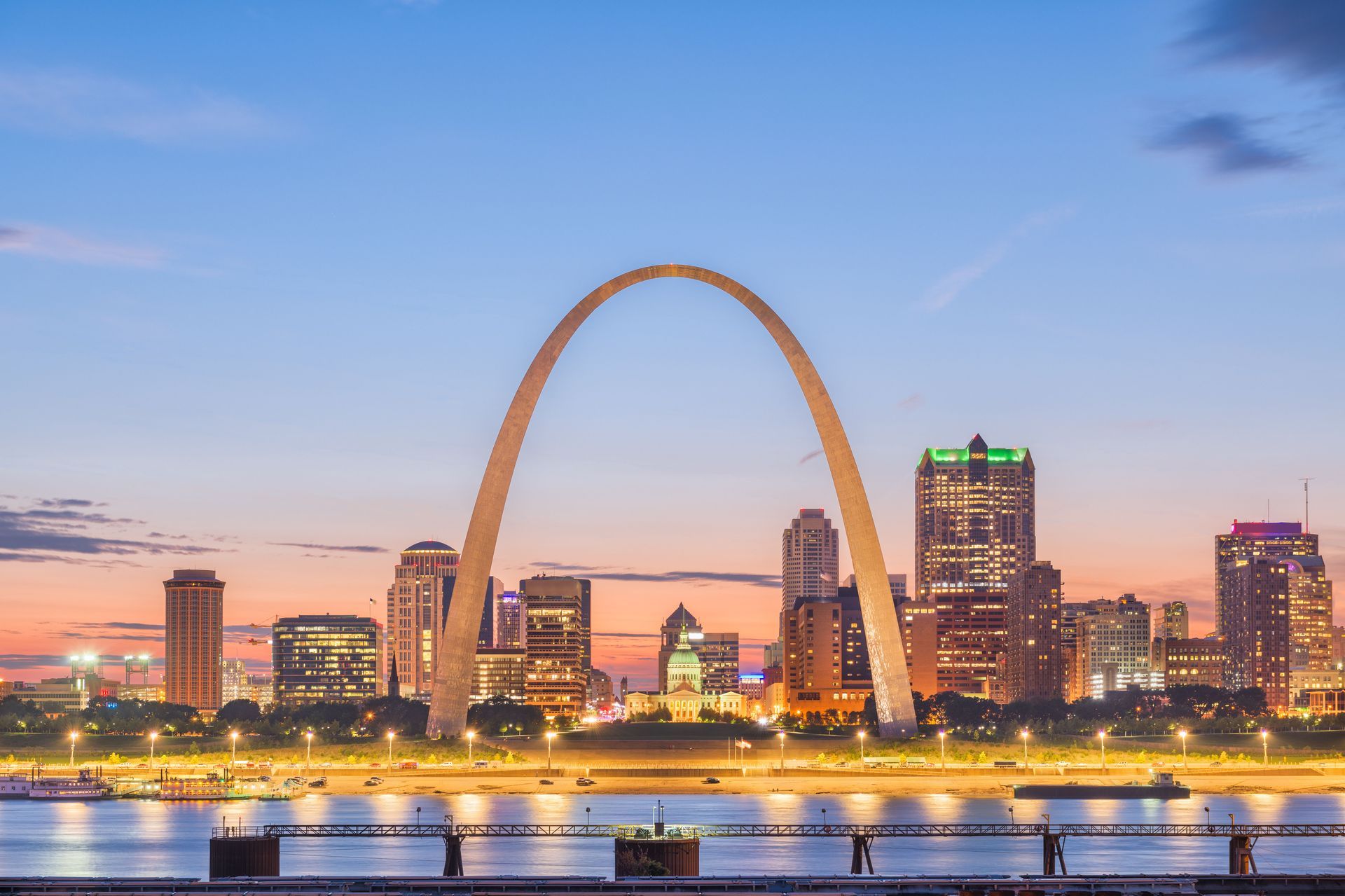 A city skyline with the st. louis arch in the foreground.
