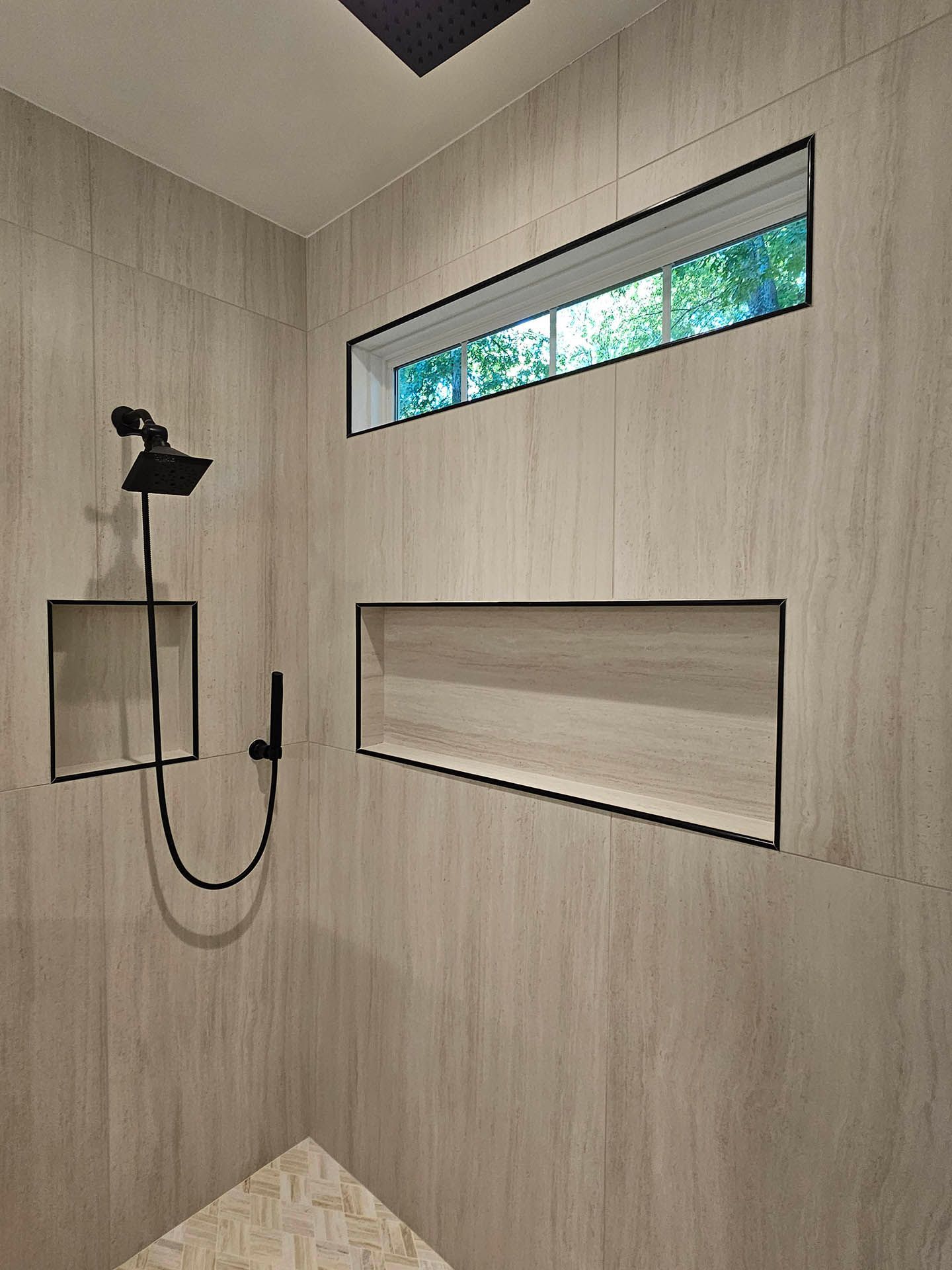 A shower with a window and a shower head.