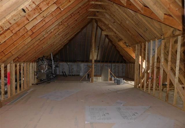 An empty attic with a wooden roof and a wooden floor.