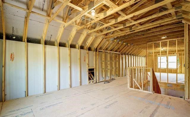 A room in a house under construction with wooden beams and walls.