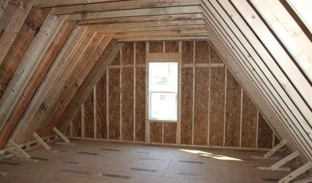 The attic of a house is being built and has a window.