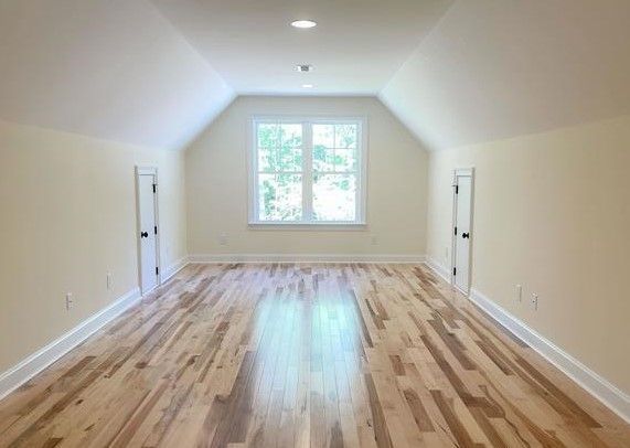 An empty room with hardwood floors and a window