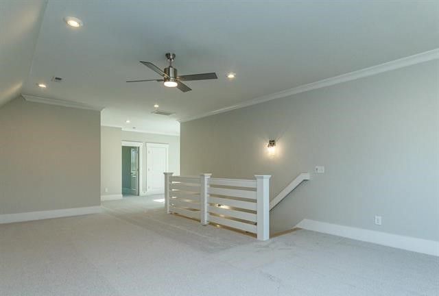 An empty room with a ceiling fan and stairs