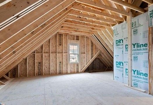 There is a window in the attic of a house under construction.