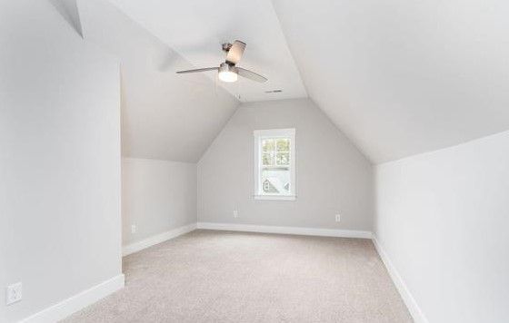 An empty room with a ceiling fan and a window.