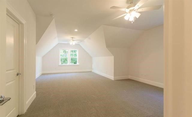 An empty room with a ceiling fan and a window.