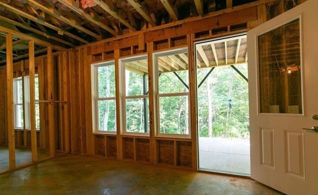 An empty room with a door and windows in a house under construction.