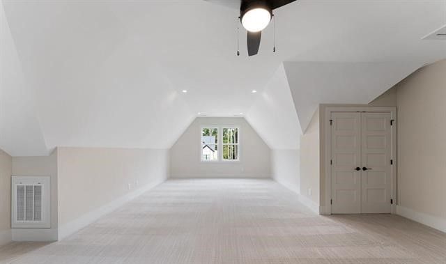 An empty attic with a ceiling fan and a window