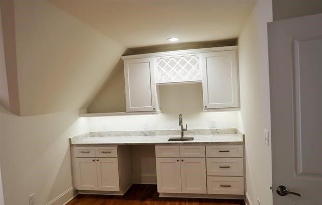 A kitchen with white cabinets and a sink