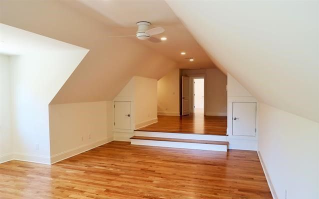 An empty room with hardwood floors and white walls